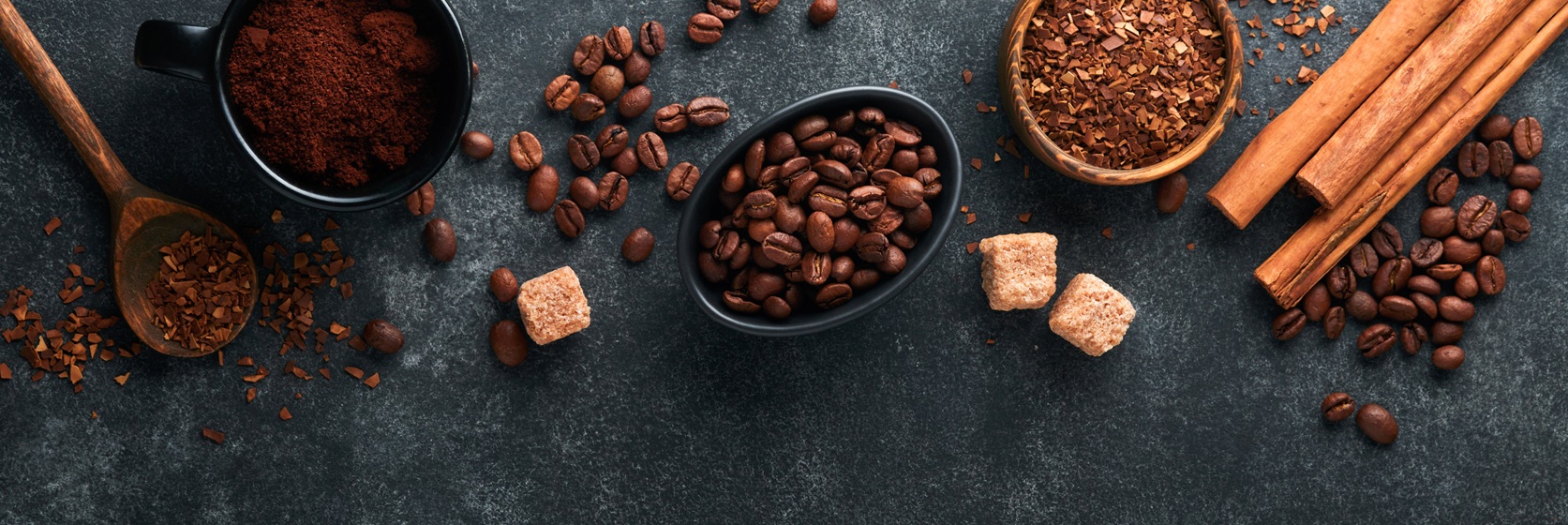Kaffeebohnen und gemahlener Kaffee auf dunkler Oberfläche