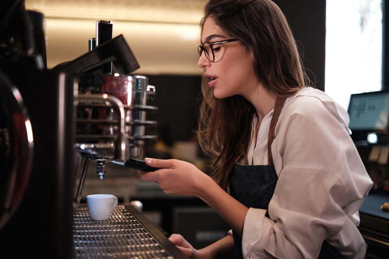 Barista bereitet Espresso an einer Siebträgermaschine zu.